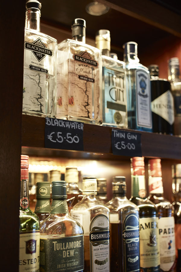 Bar shelving with alcohol bottles signage prices