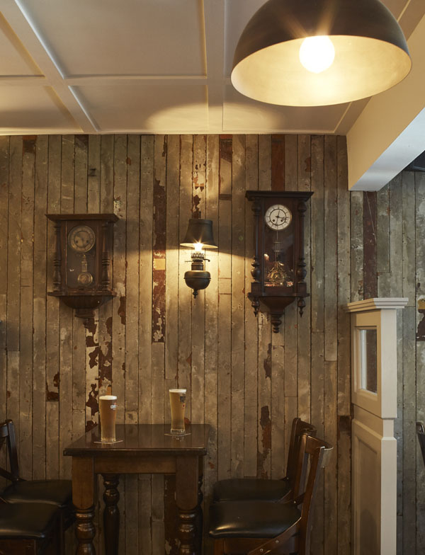 Bar area drinks seating pendant lights timber paneling on wall with 2 beautiful wall clocks