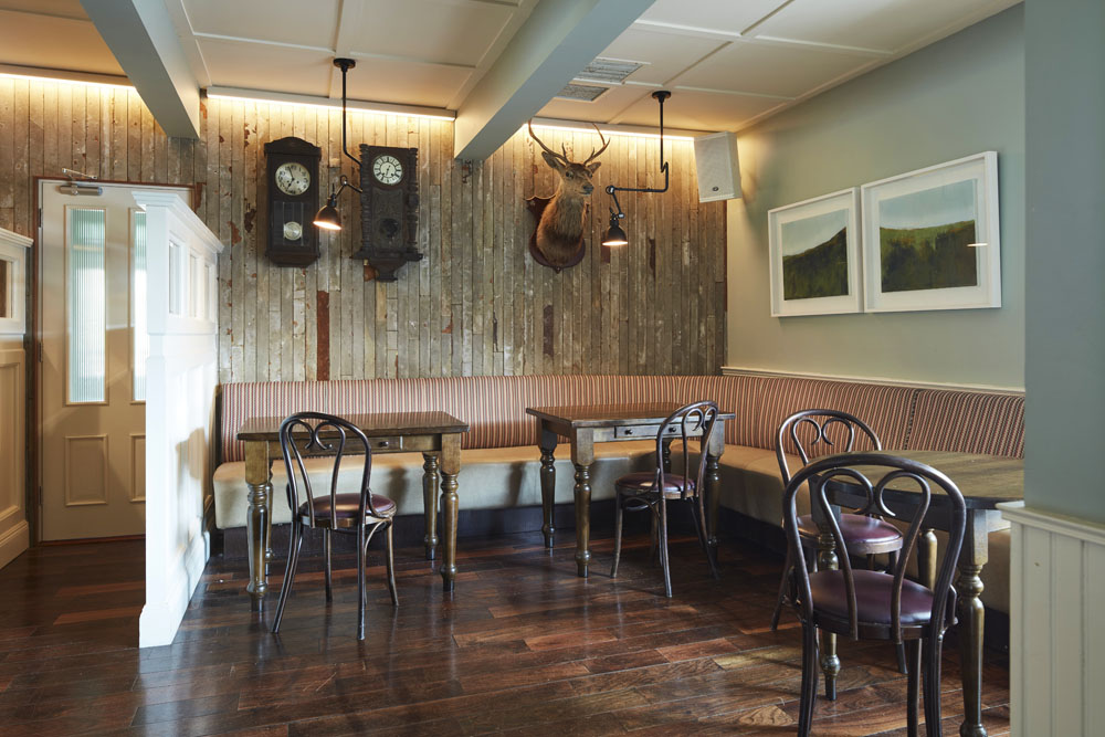 Bar seating tables timber wall paneling, pendant lighting, wall art, deer head wall display